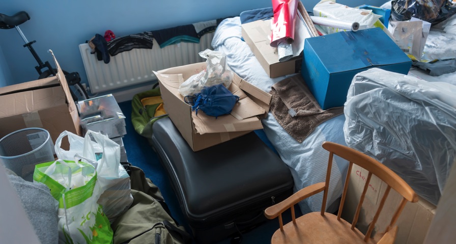 Stacks of books and papers before Madison Heights hoarding cleanup sorting
